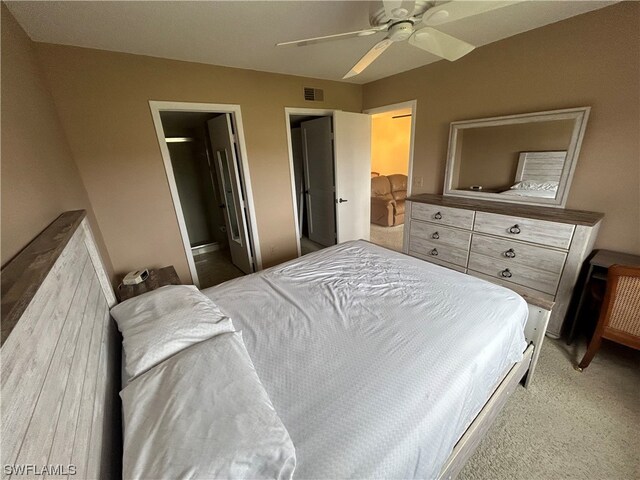 carpeted bedroom featuring connected bathroom, a spacious closet, and ceiling fan