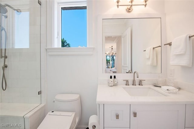 bathroom with toilet, tiled shower, and vanity