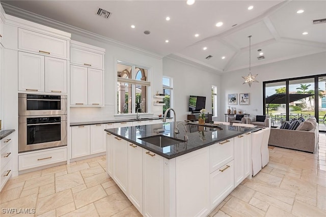 kitchen featuring stone tile floors, visible vents, open floor plan, and a sink
