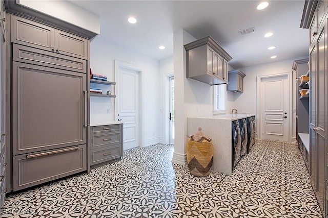 kitchen with visible vents, recessed lighting, gray cabinetry, light countertops, and washer and dryer