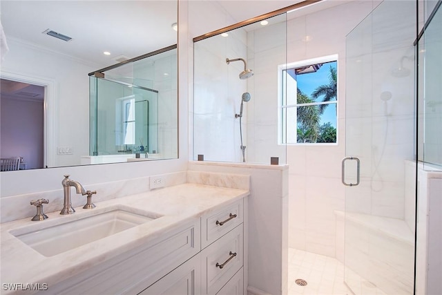 bathroom featuring visible vents, vanity, a stall shower, and crown molding