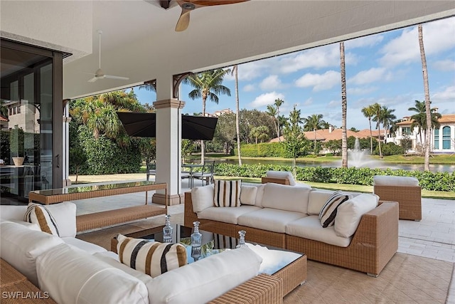 sunroom with a water view and ceiling fan