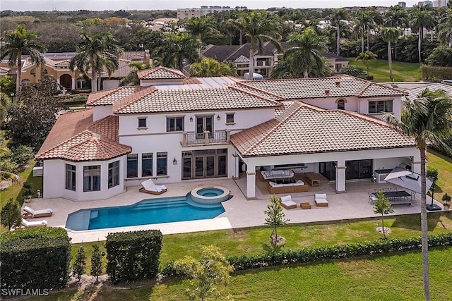 back of property with an outdoor living space, french doors, a patio, and a balcony