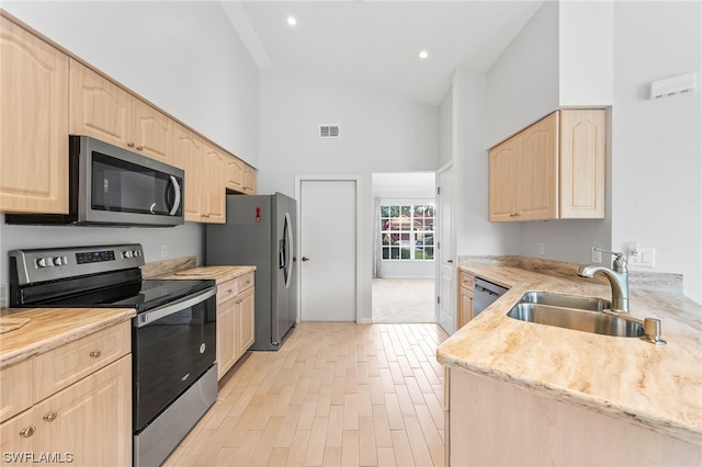 kitchen featuring light brown cabinets, high vaulted ceiling, appliances with stainless steel finishes, and sink