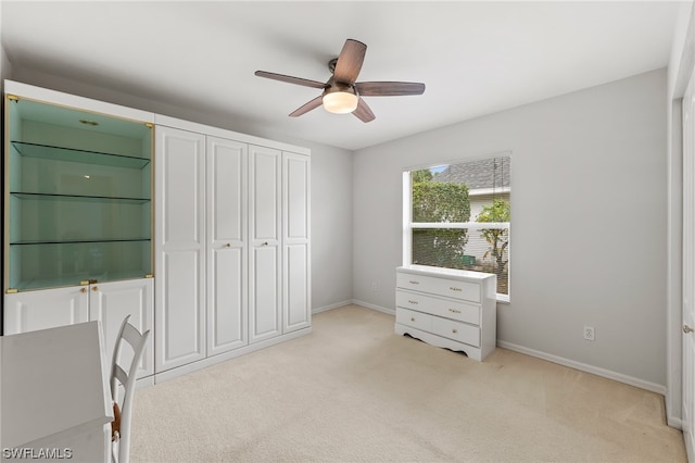 unfurnished bedroom featuring a closet, light colored carpet, and ceiling fan