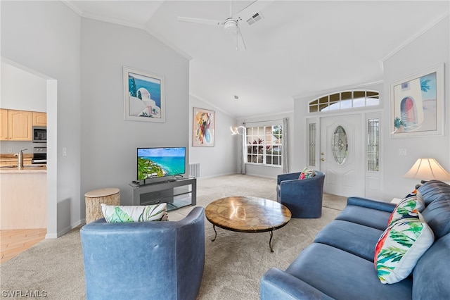 carpeted living room featuring crown molding, ceiling fan with notable chandelier, vaulted ceiling, and sink