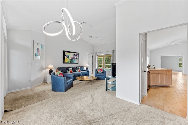 living room with vaulted ceiling, light colored carpet, ceiling fan with notable chandelier, and sink