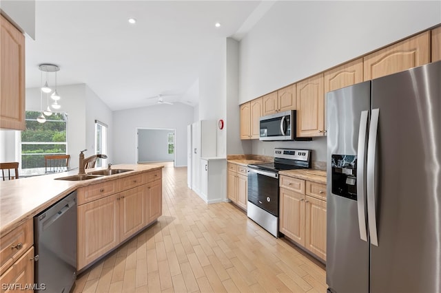 kitchen with ceiling fan, pendant lighting, sink, stainless steel appliances, and light wood-type flooring