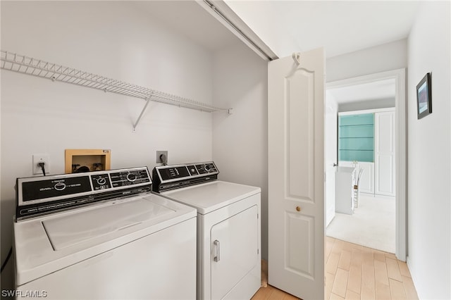 washroom with washer hookup, light hardwood / wood-style floors, hookup for an electric dryer, and washer and clothes dryer