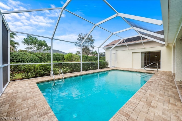 view of swimming pool featuring a patio and glass enclosure