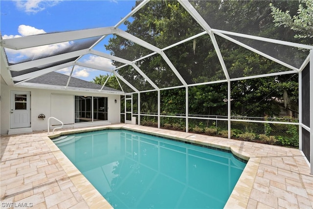 view of swimming pool featuring a patio area and glass enclosure