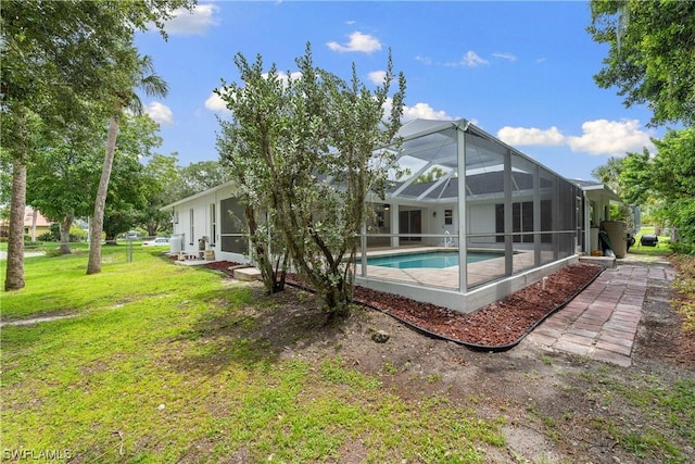 rear view of property with a yard and a lanai