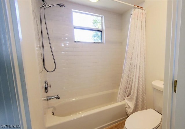 bathroom featuring shower / tub combo and toilet