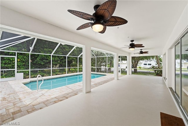 view of swimming pool featuring ceiling fan, glass enclosure, and a patio