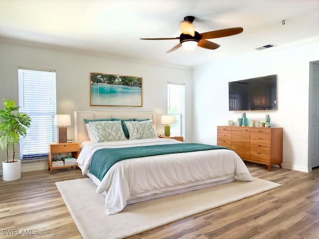 bedroom with crown molding, wood-type flooring, and ceiling fan