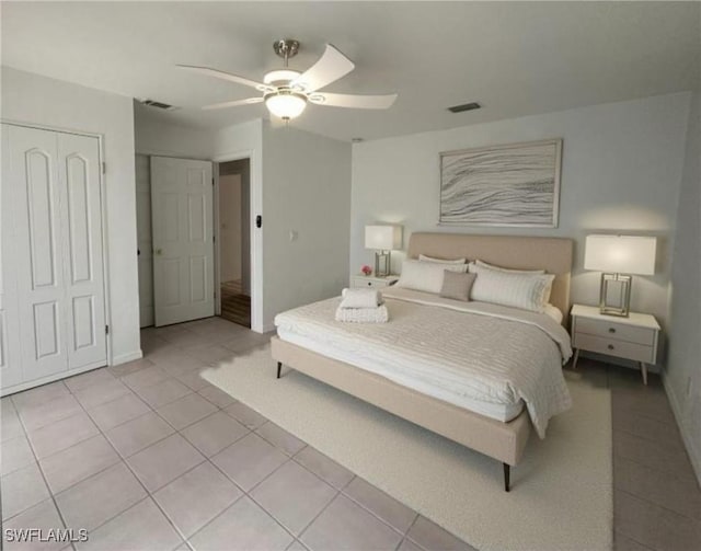 tiled bedroom featuring ceiling fan and a closet