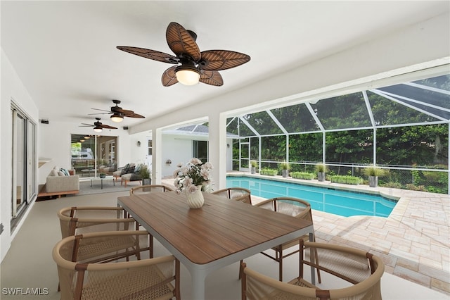 view of swimming pool with a patio, ceiling fan, and glass enclosure