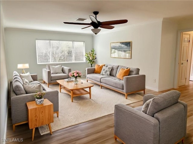 living room with crown molding, wood-type flooring, and ceiling fan