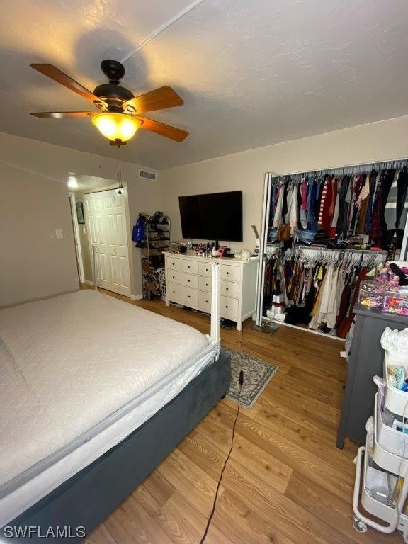 bedroom with a closet, hardwood / wood-style flooring, and ceiling fan