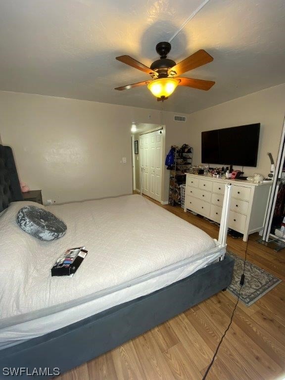 bedroom featuring ceiling fan, wood-type flooring, and a closet