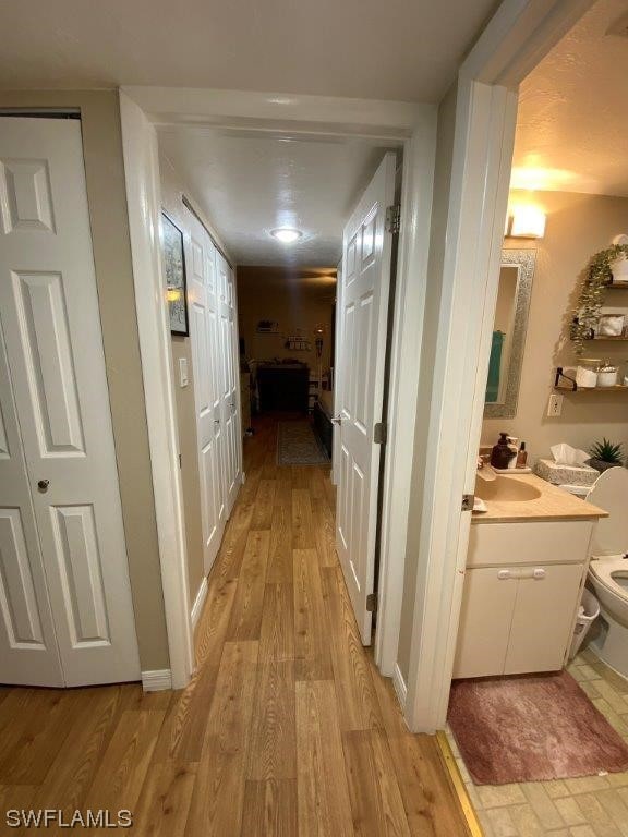 hallway featuring light hardwood / wood-style flooring and sink