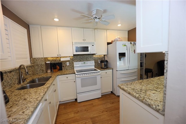 kitchen featuring sink, white cabinets, white appliances, and light hardwood / wood-style flooring