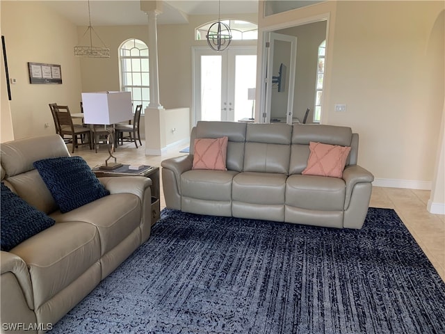 tiled living room featuring french doors and decorative columns