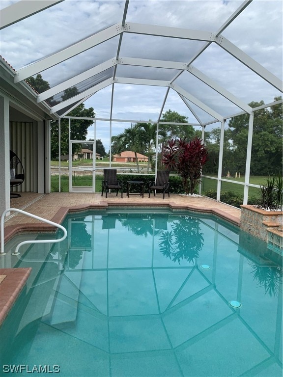 view of pool with a patio and a lanai