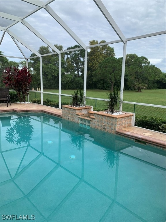 view of pool featuring a lanai and a yard