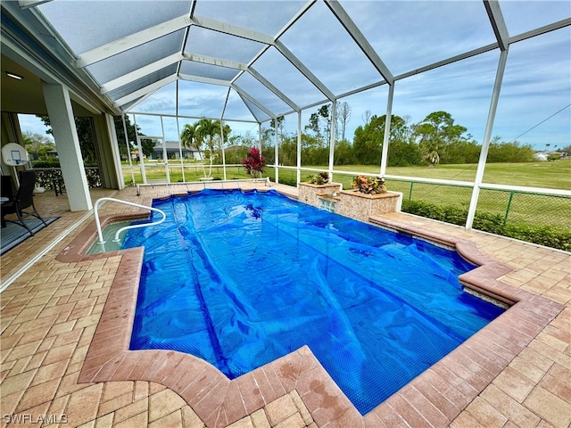 view of pool featuring glass enclosure and a patio