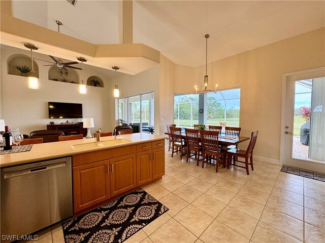 kitchen featuring decorative light fixtures, high vaulted ceiling, stainless steel dishwasher, and sink