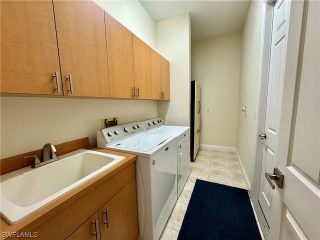 clothes washing area with light tile flooring, cabinets, independent washer and dryer, and sink