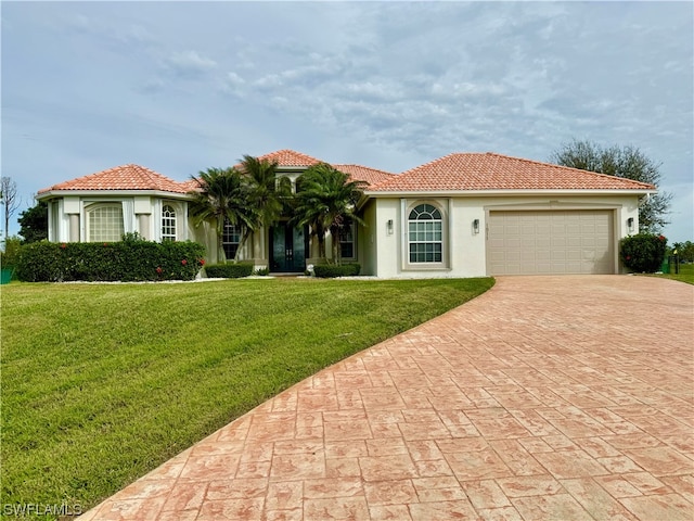 mediterranean / spanish-style house featuring a front yard and a garage