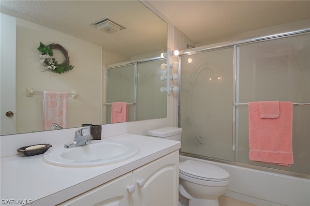 full bathroom with toilet, tile flooring, shower / bath combination with glass door, a textured ceiling, and vanity