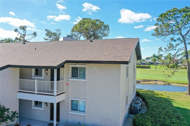 back of property with a balcony and a yard