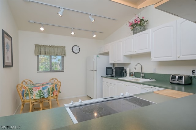 kitchen featuring range, sink, white cabinets, rail lighting, and white refrigerator