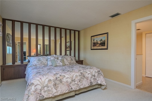 bedroom with light carpet and a textured ceiling