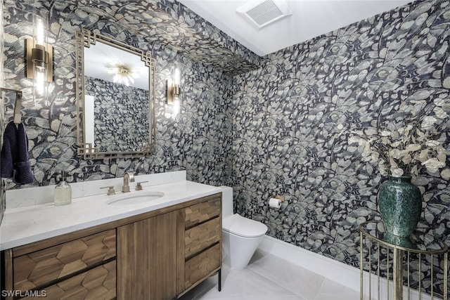 bathroom featuring toilet, tile floors, and vanity