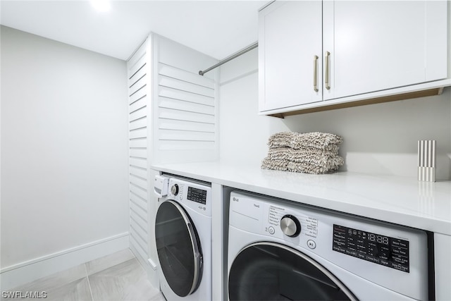 laundry area with light tile floors, cabinets, and washer and dryer