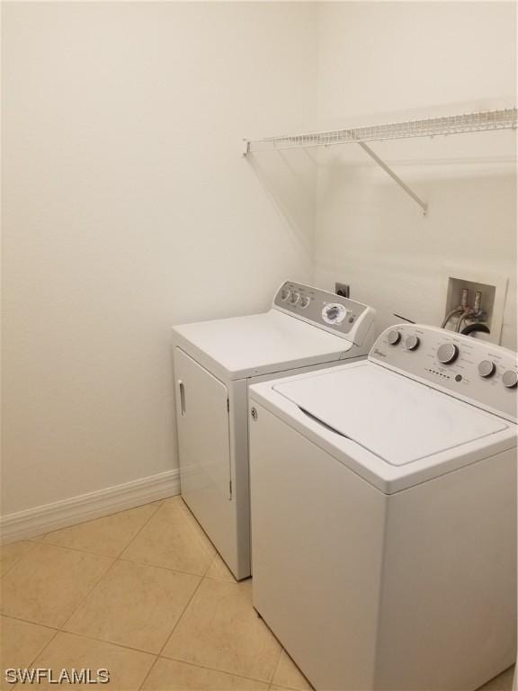 laundry room with washing machine and dryer and light tile patterned flooring