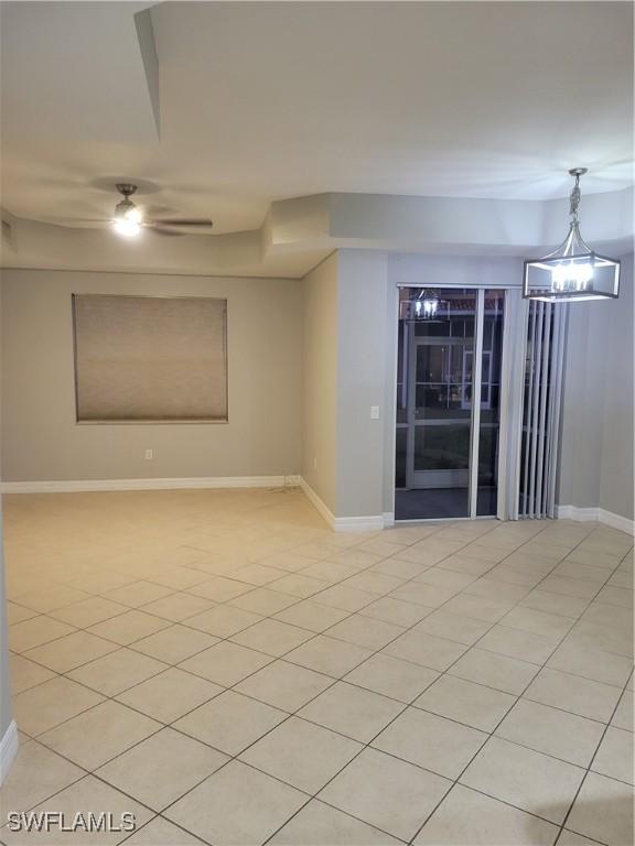 tiled empty room featuring ceiling fan