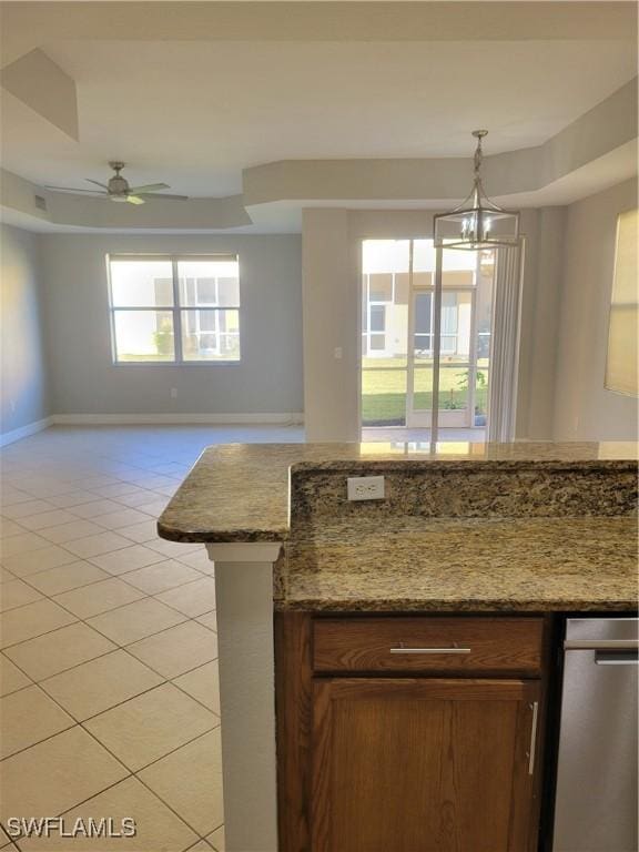 kitchen with light tile patterned floors, ceiling fan with notable chandelier, decorative light fixtures, and light stone counters