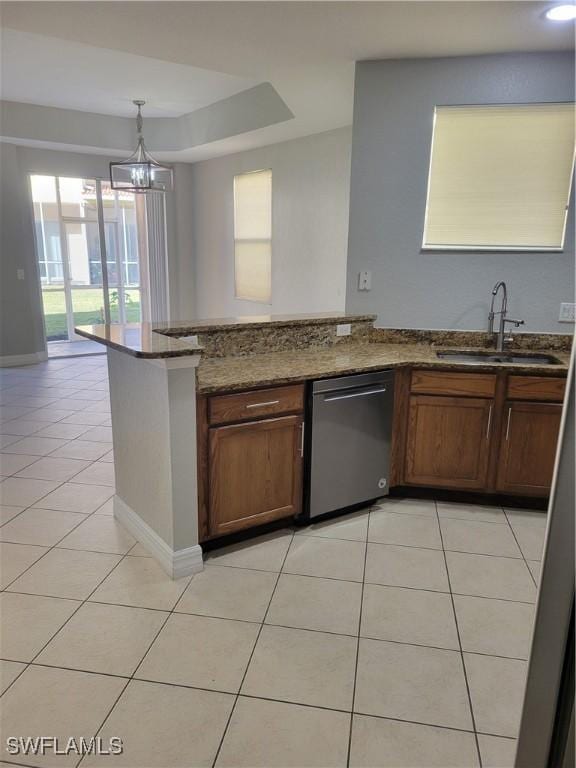 kitchen with stainless steel dishwasher, sink, light tile patterned floors, an inviting chandelier, and stone counters