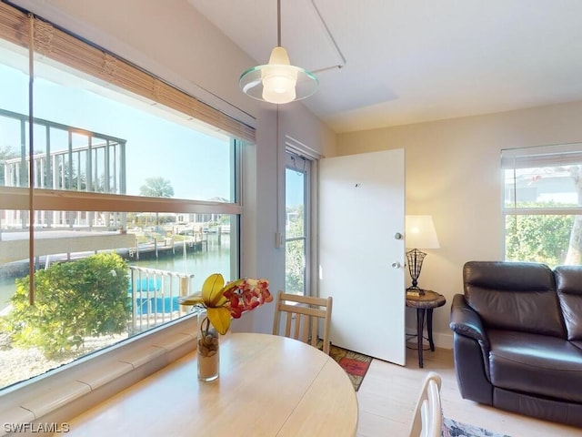 dining area with light hardwood / wood-style flooring and a water view