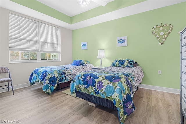 bedroom with wood finished floors and baseboards