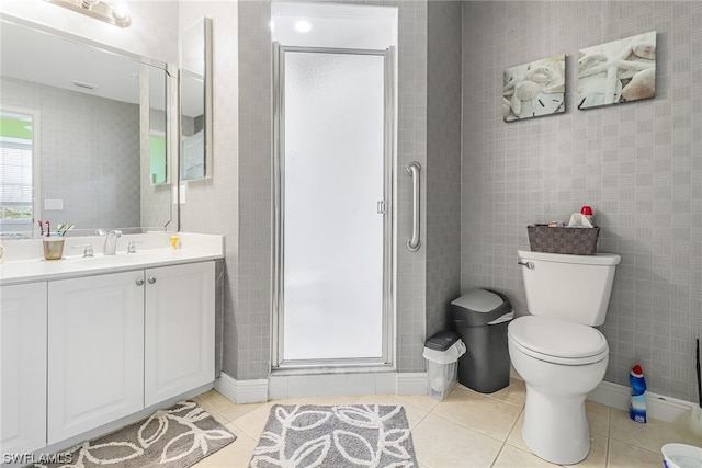 full bathroom featuring tile walls, toilet, a shower stall, vanity, and tile patterned flooring