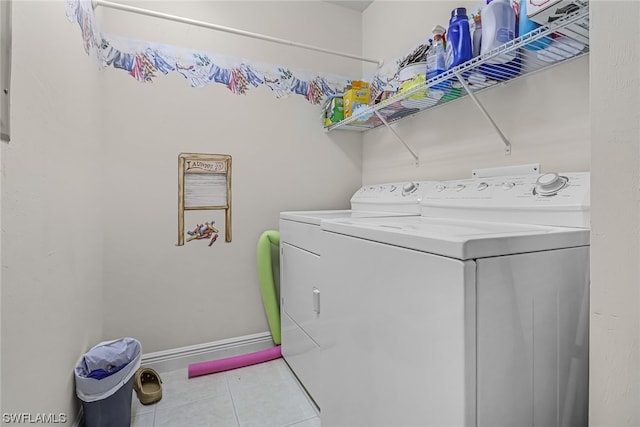 laundry room featuring laundry area, tile patterned flooring, baseboards, and independent washer and dryer