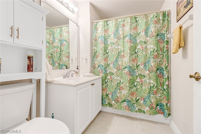 bathroom with toilet, vanity, and tile patterned floors