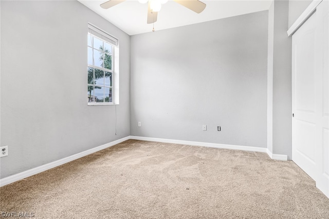 spare room with ceiling fan and carpet