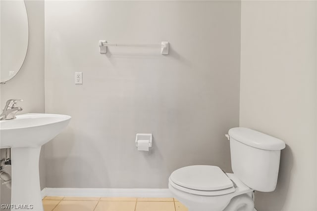 bathroom with toilet, tile flooring, and sink